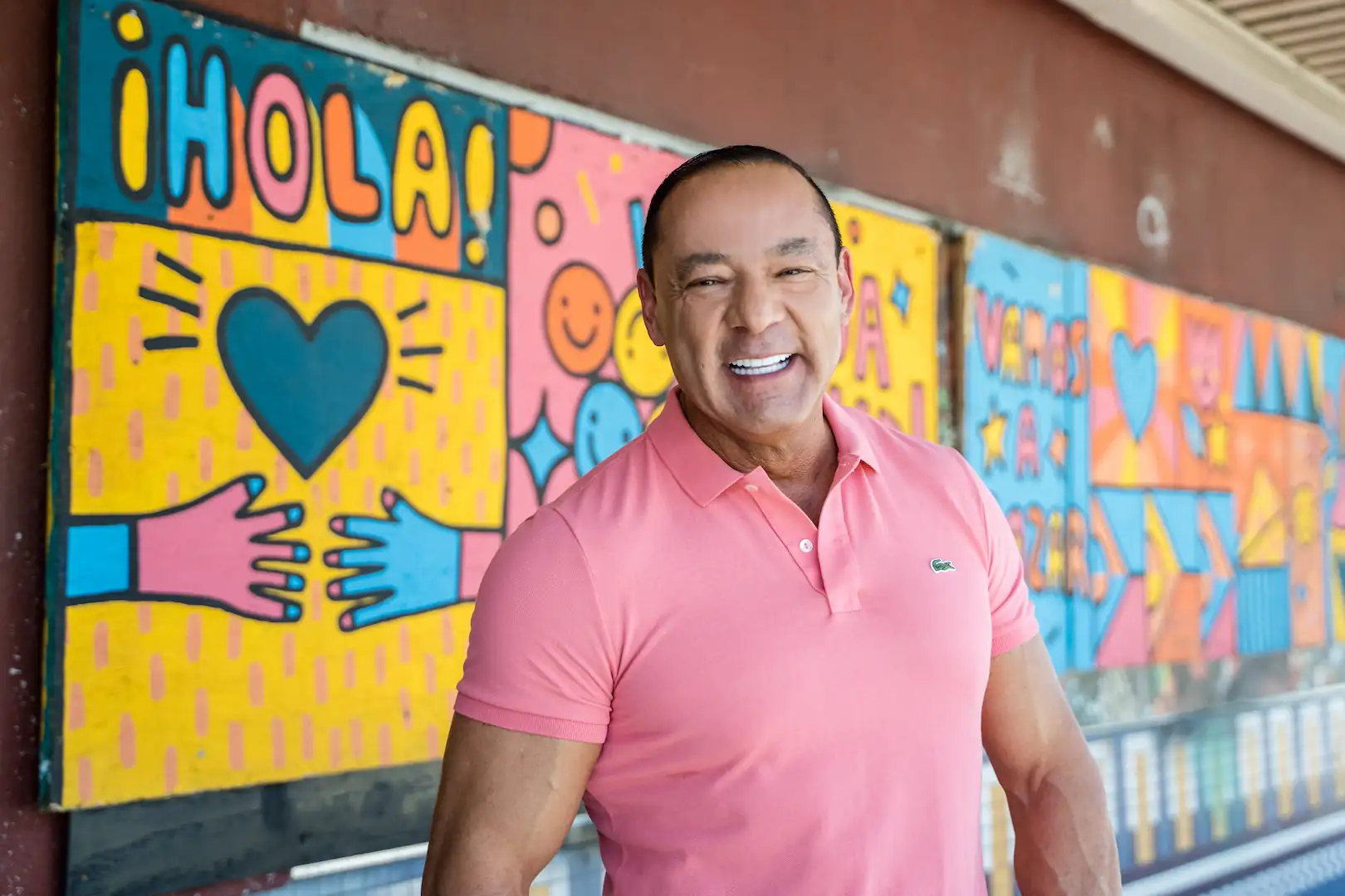 Smiling Espire patient standing in front of a colorful mural, showing a bright and confident smile.