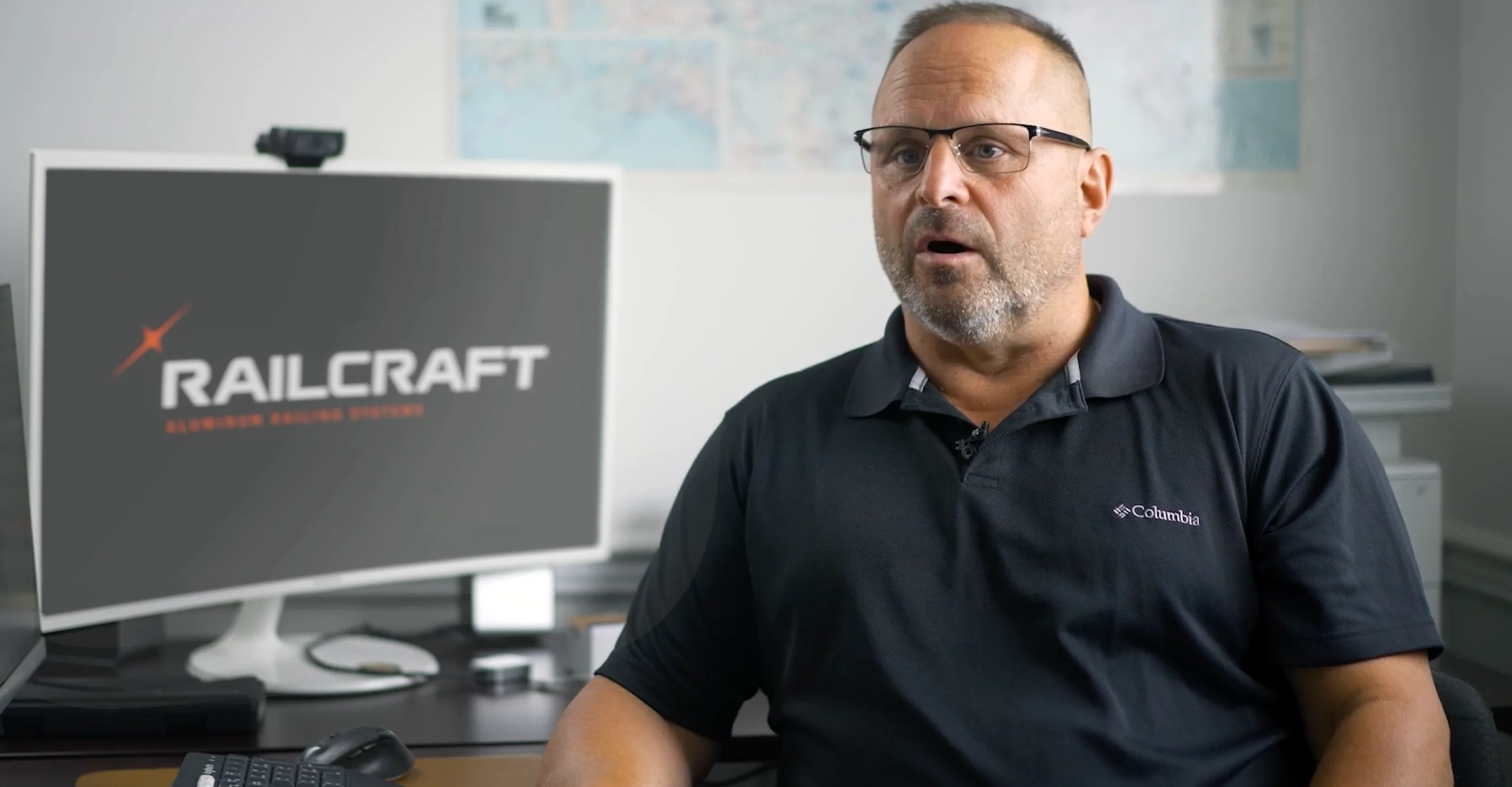 Man in dark polo being interviewed with Railcraft branding in background