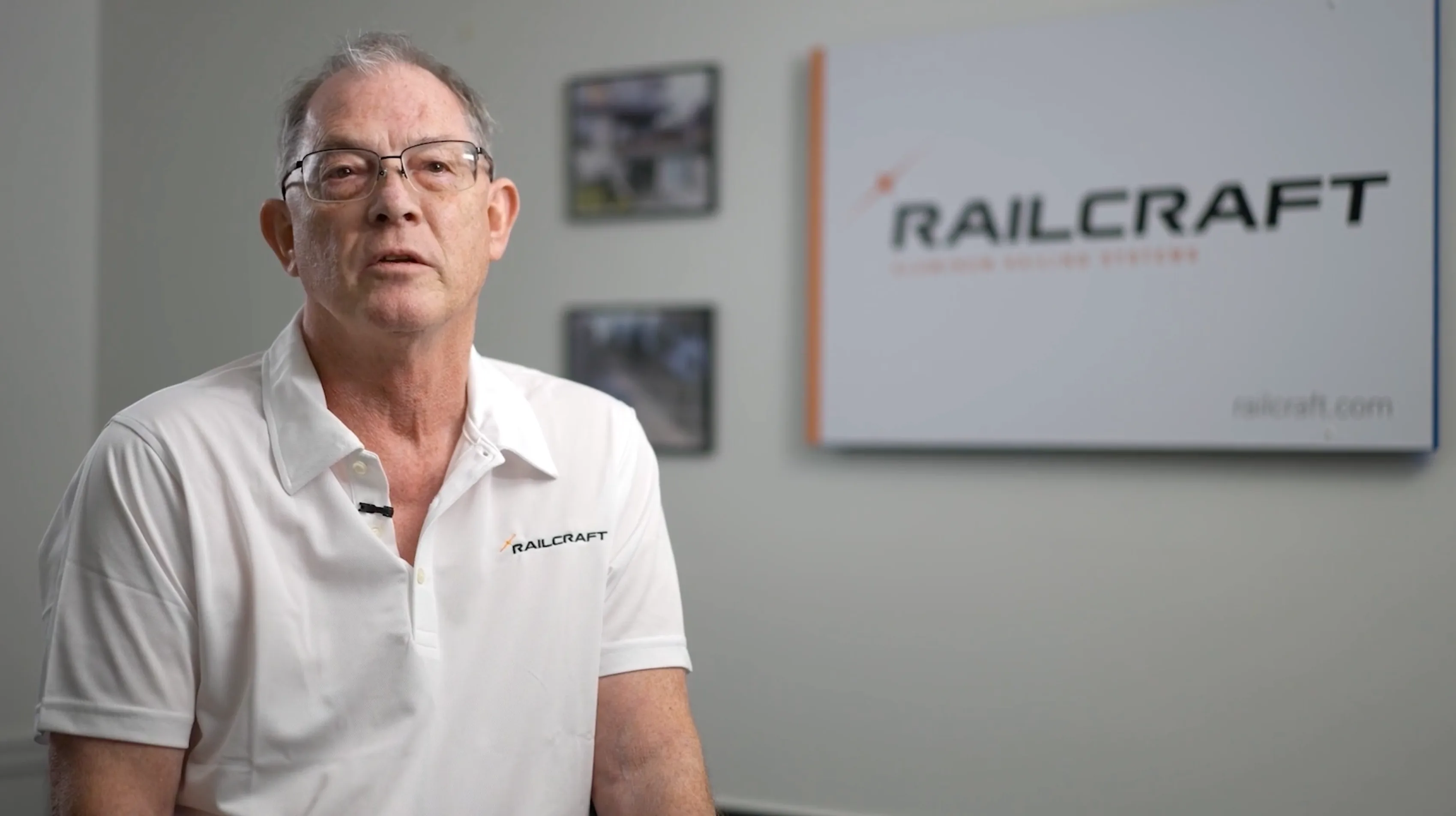 Man in white Railcraft polo being interviewed at manufacturing facility