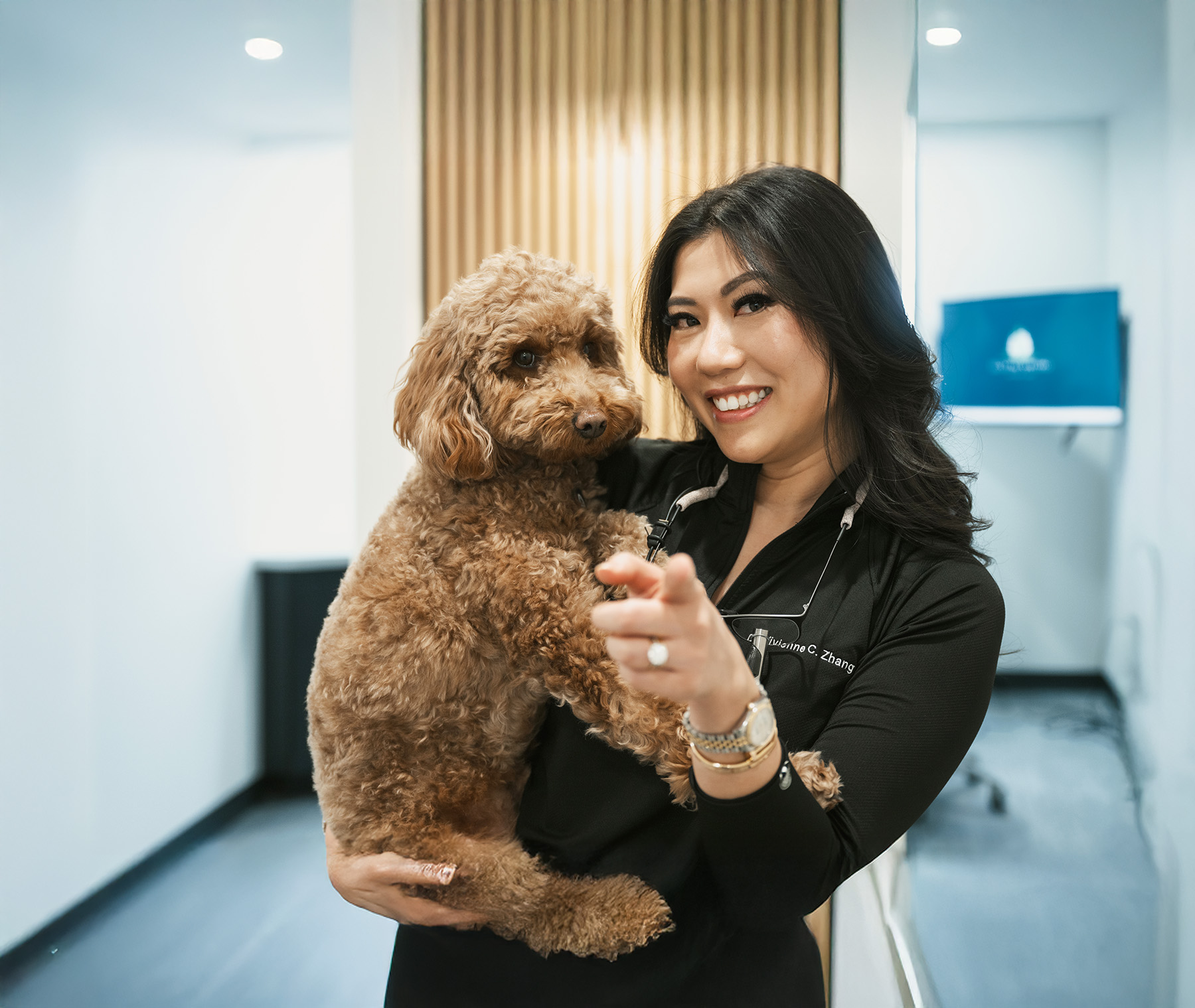 Dentist smiling while holding a cute dog. 