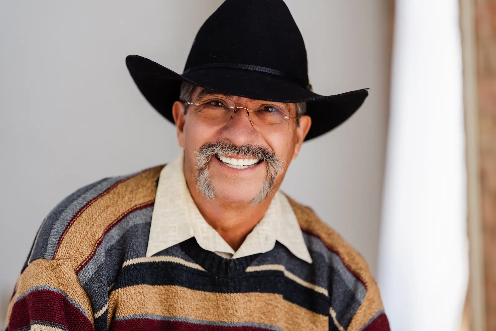 Smiling senior man in a cowboy hat showing his bright, healthy smile after dental care at Espire Dental.