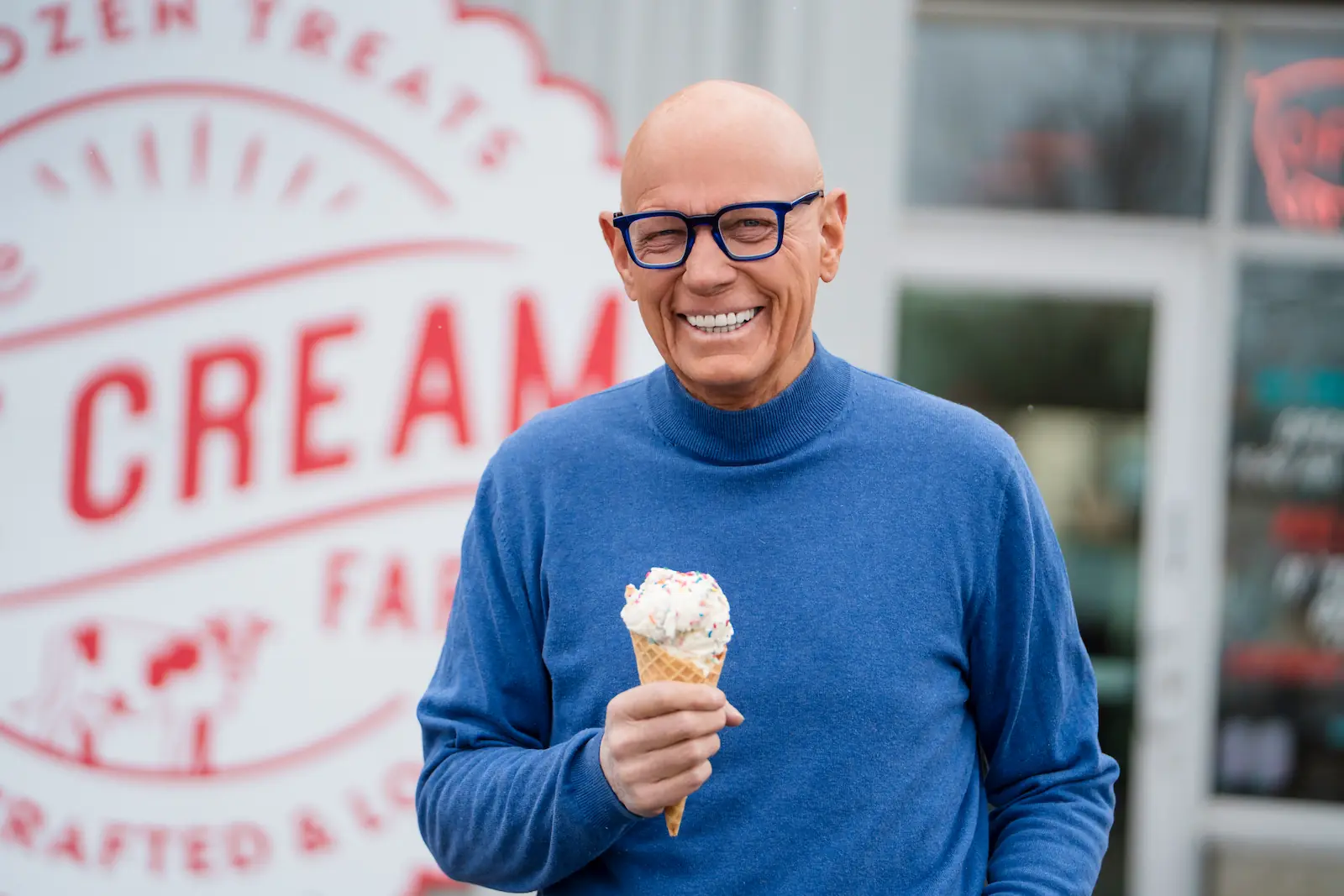 Older man with a bright, confident smile enjoying ice cream after senior dental care at Espire Dental.