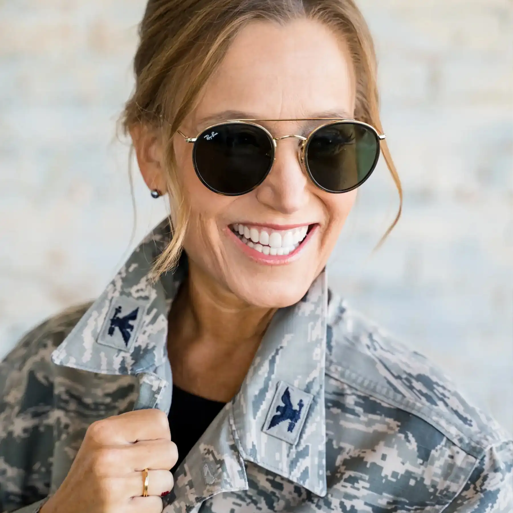 Smiling woman in an Air Force uniform, showing confidence and a bright, healthy smile.