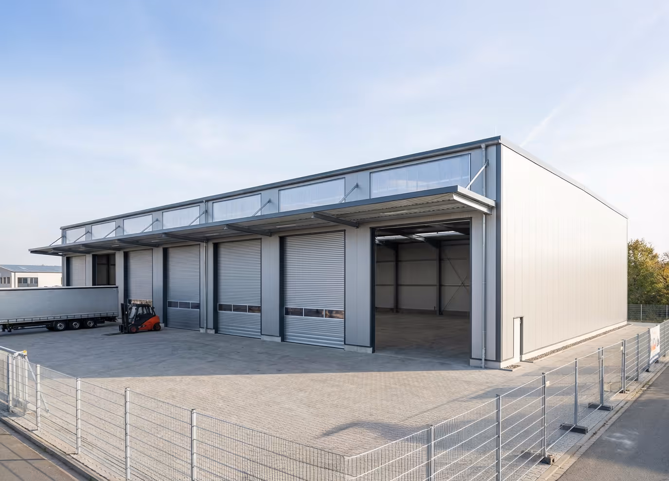 Moderne Lagerhalle mit Docktoren und befestigter Fläche.