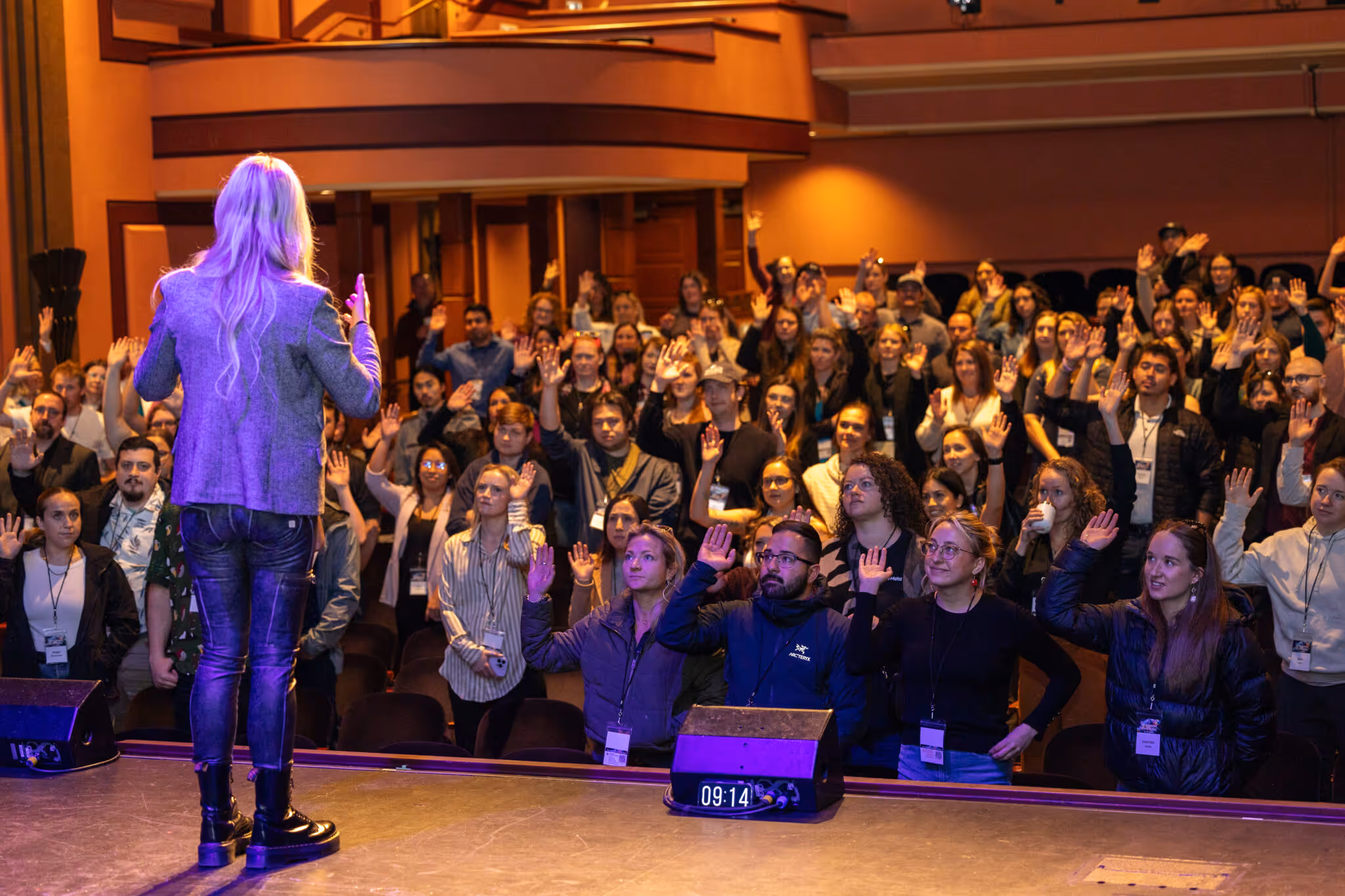A woman is standing on a stage, surrounded by a crowd of people
