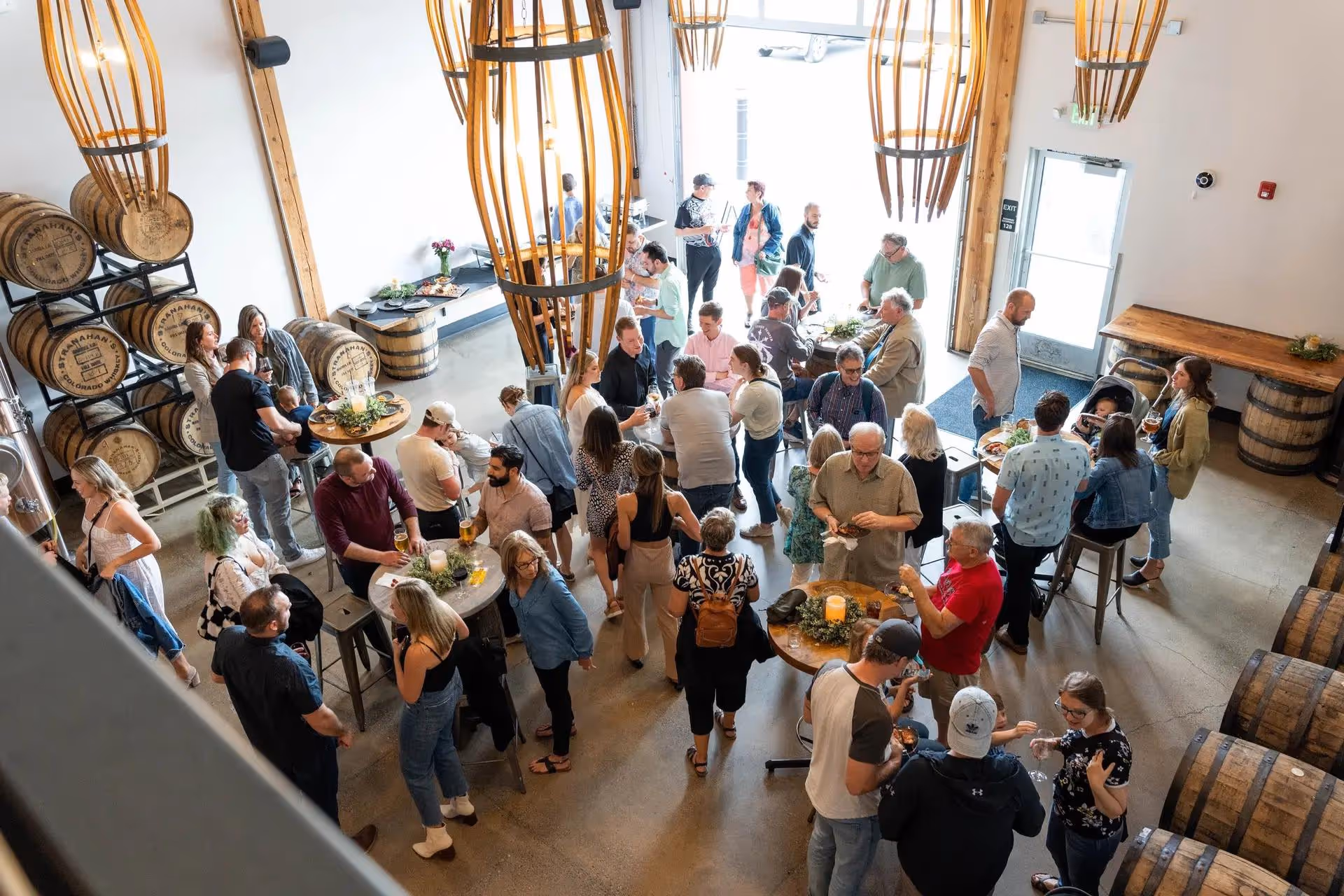 An overhead view of a crowded room filled with people socializing at tables. 