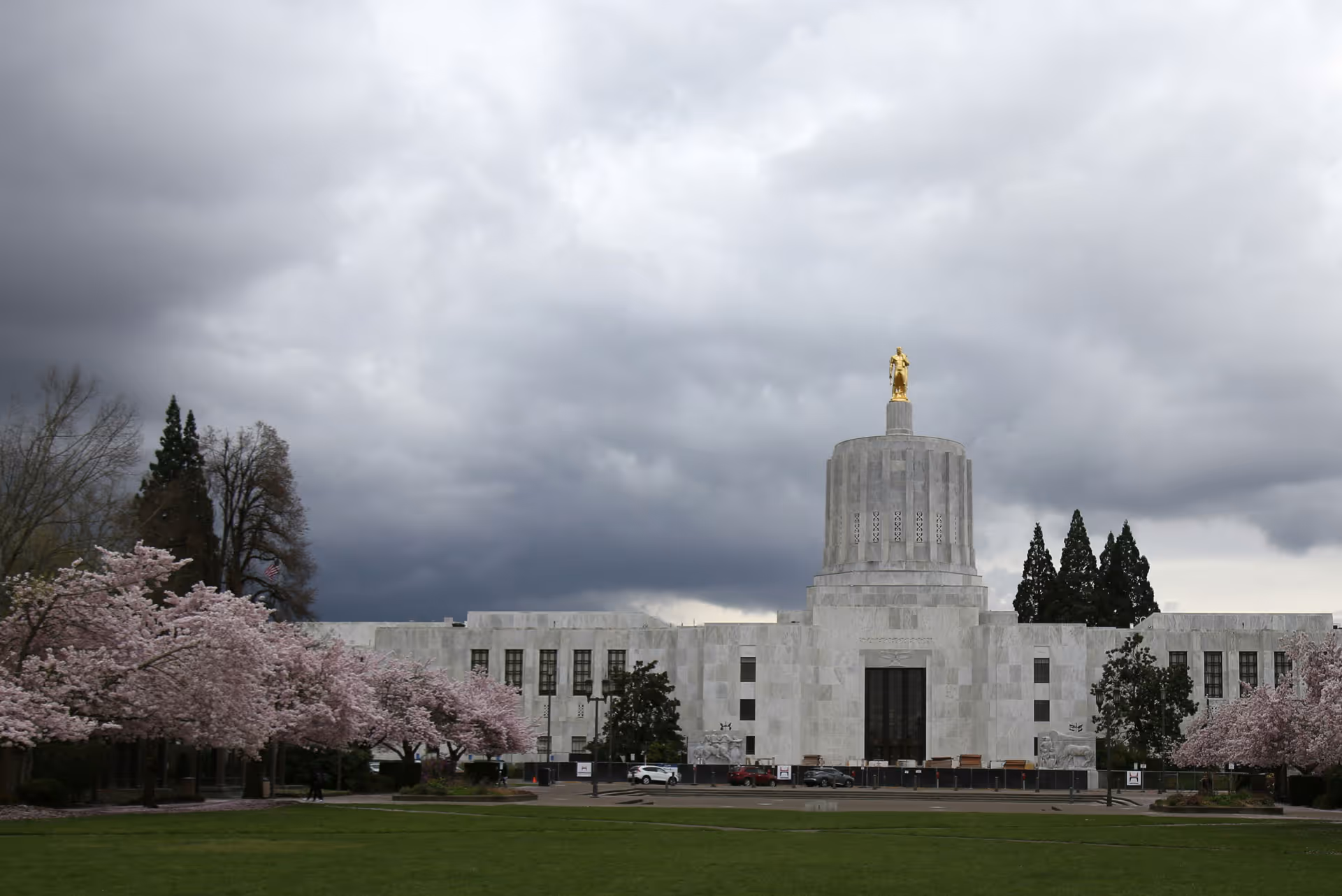 A large white building with a golden statue on top of it.