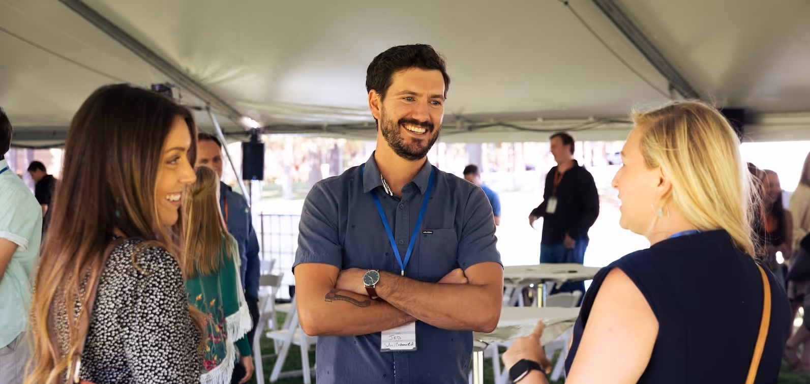 A group of people standing under a tent.