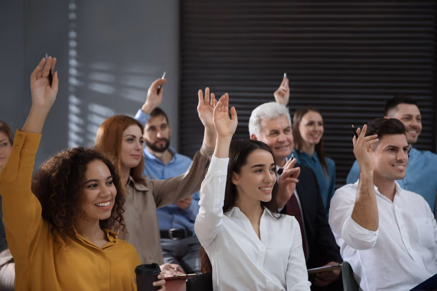 A group of people raising their hands in the air.