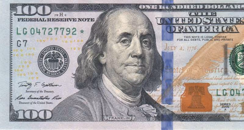 Front side of a US 100 dollar bill featuring Benjamin Franklin's portrait and security features.