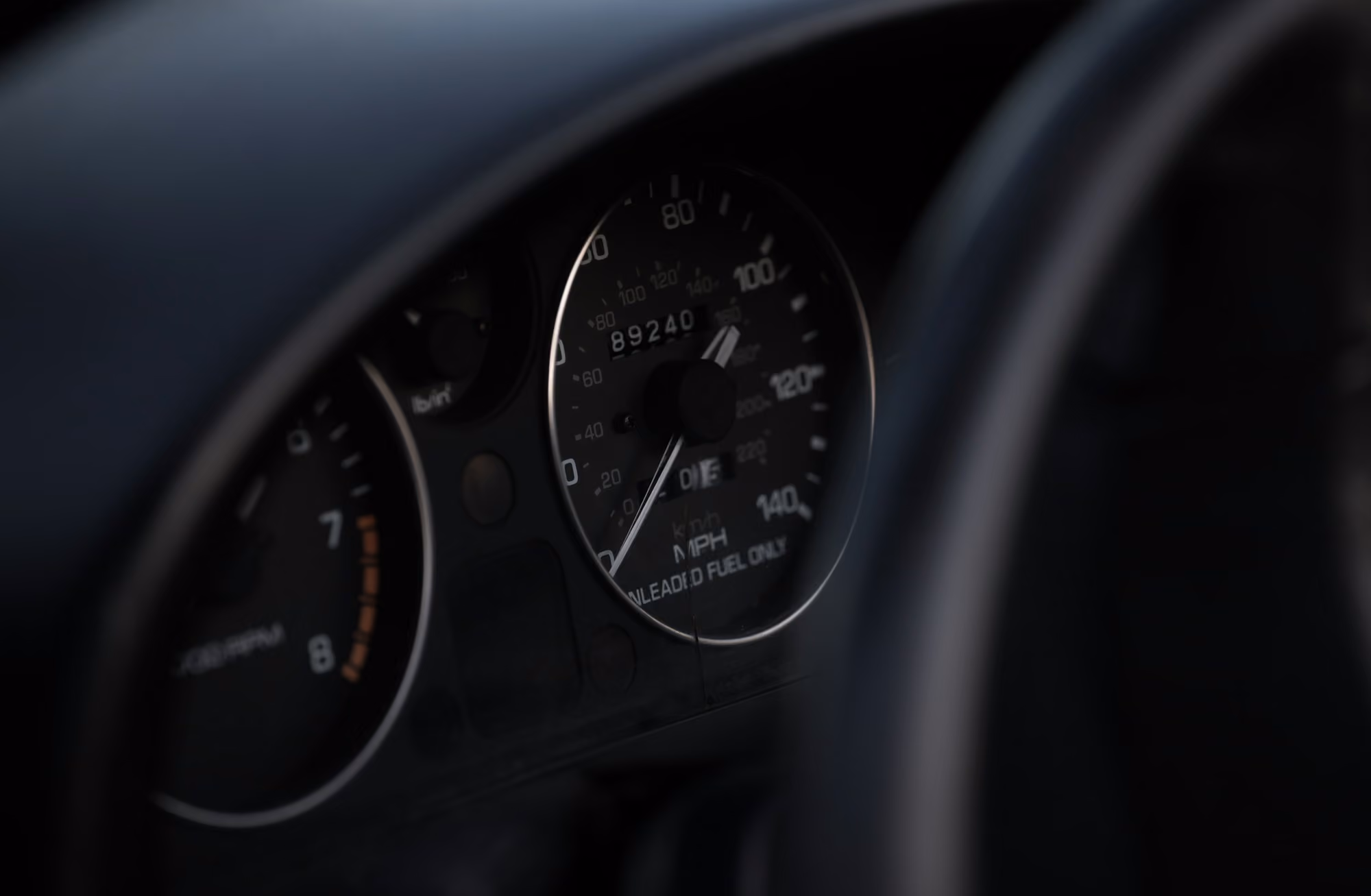 Close-up of a car dashboard showing the speedometer and odometer reading 89240 miles.