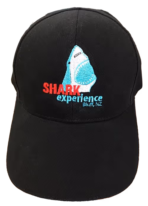 A cap with an embroidered logo on it of Shark Experience, Bluff