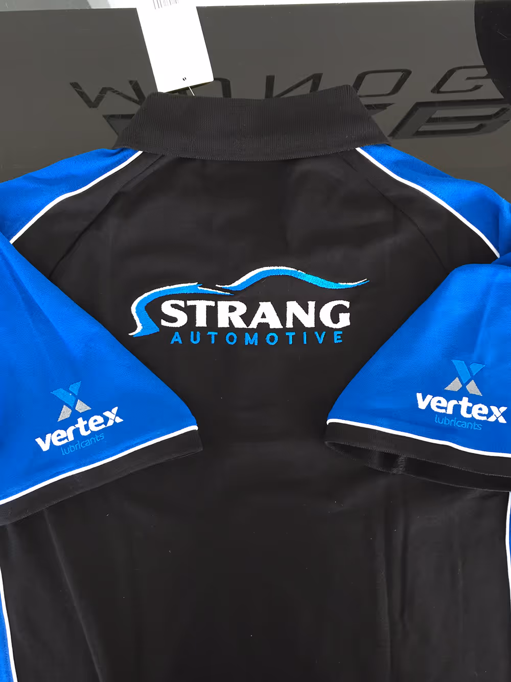 Embroidered work shirt including embroidered logo on back and sleeves