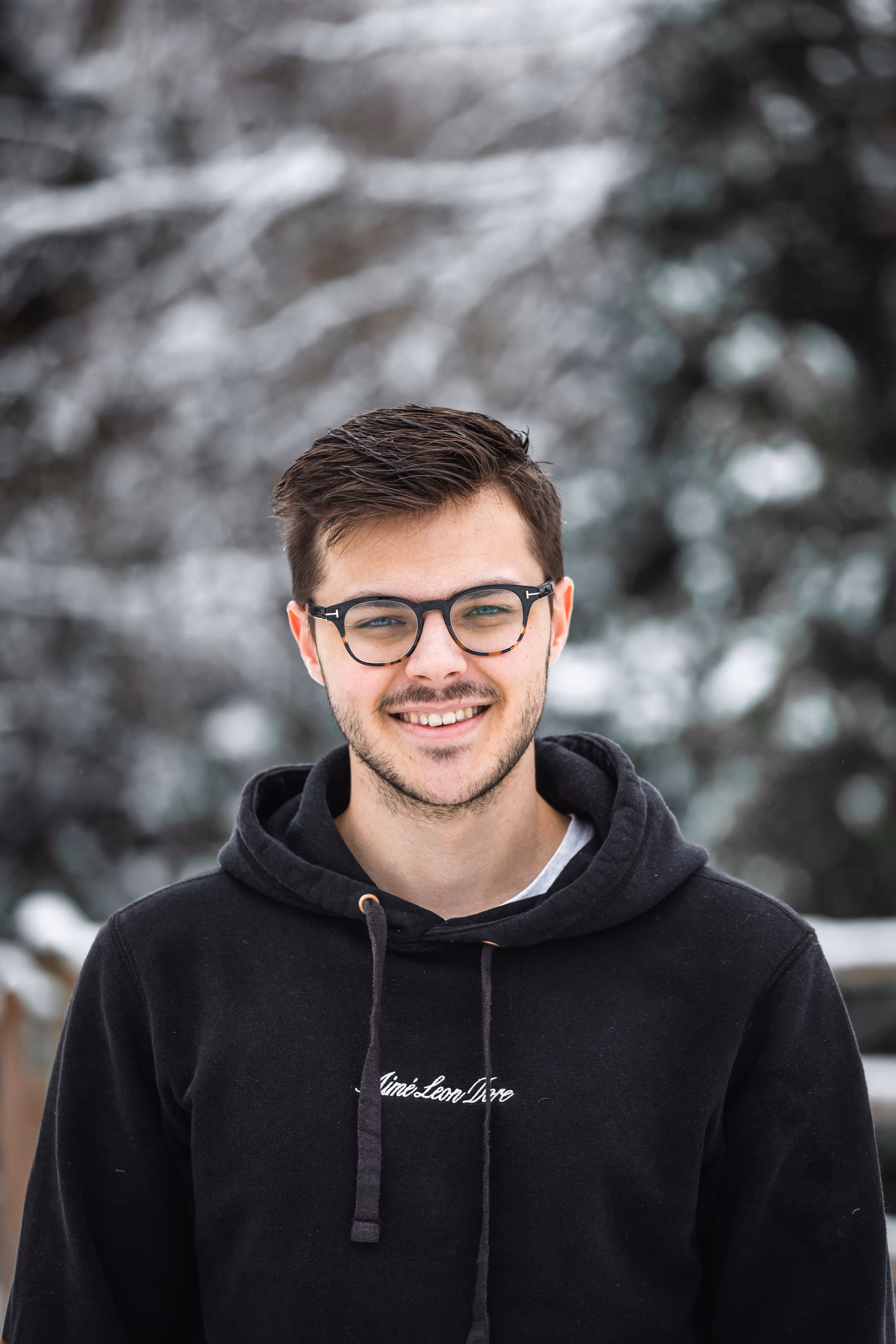 Photo of man with glasses smiling at camera