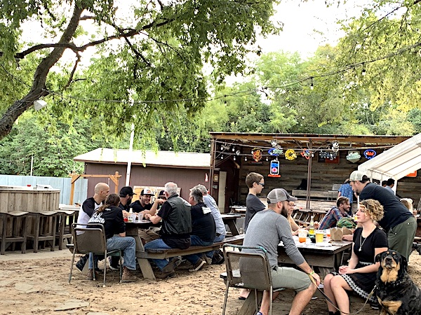 Little Darlin bar South Austin outdoor patio with guests at picnic tables under trees