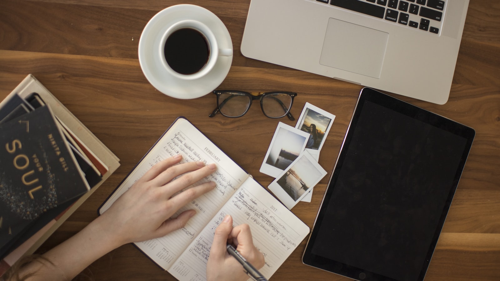 An overhead view of a notebook, coffee, and laptop on a desk while planning a short-term rental market strategy