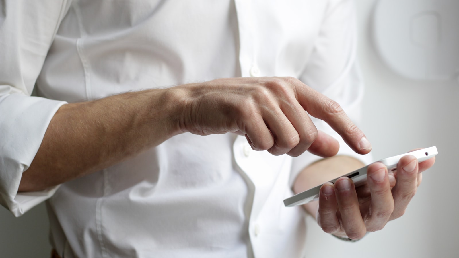 A hand holding a smartphone with a messaging app open, illustrating short-term rental guest message templates