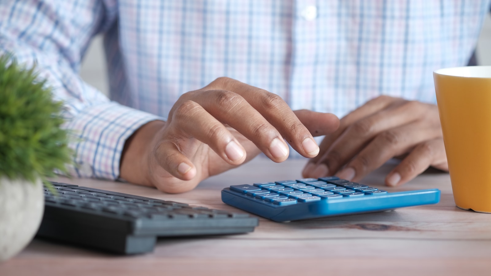 Hands using a calculator with financial documents on a desk, illustrating short-term rental deal underwriting