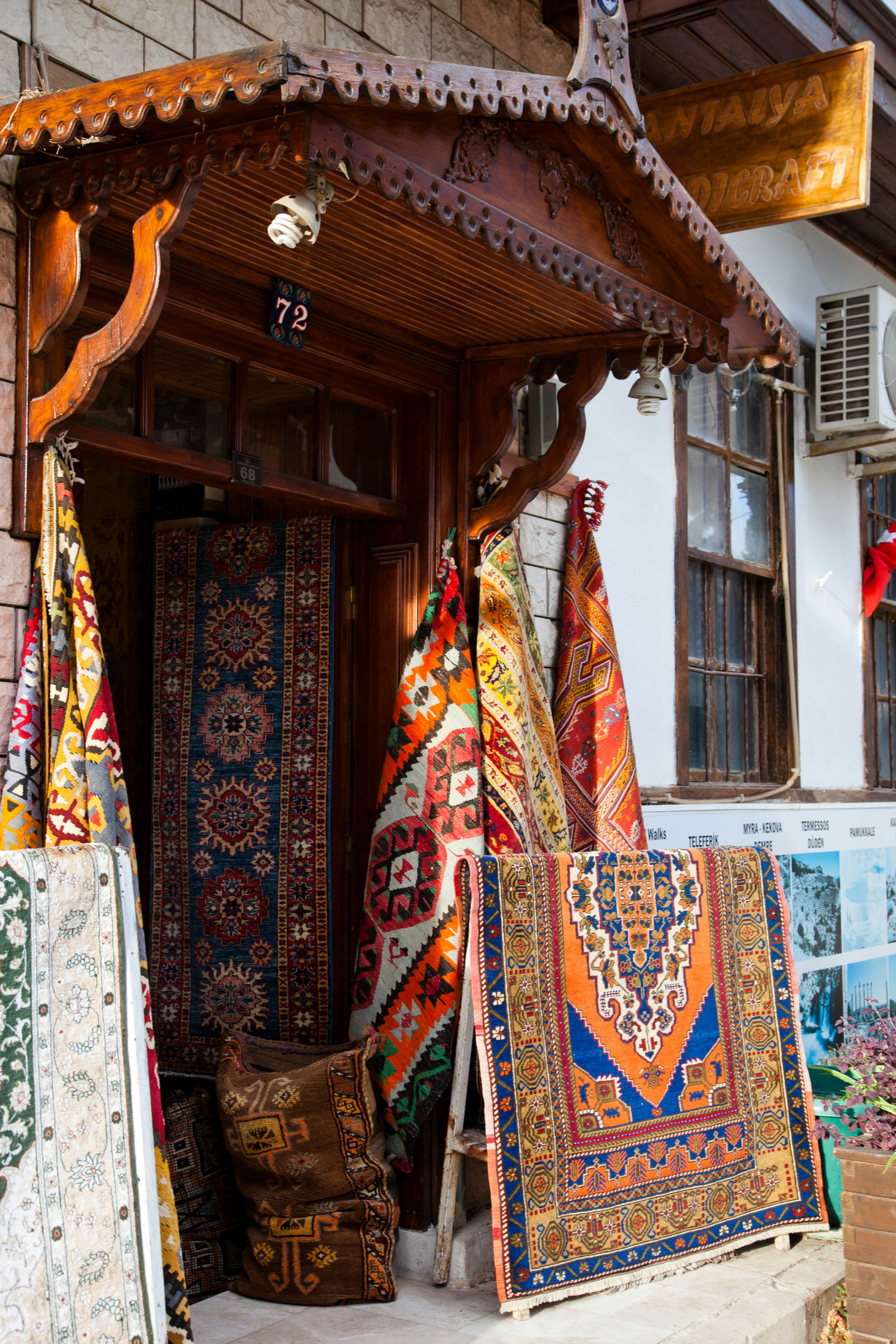 Colorful handwoven rugs displayed outside a shop in Antalya, Turkey