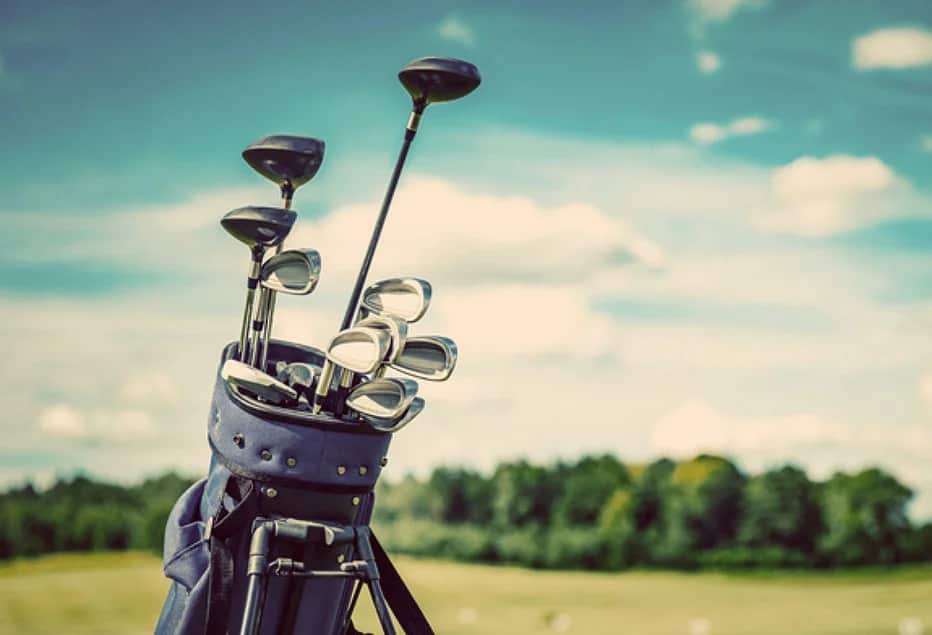 Golf bag pictured on fairway on a sunny day.