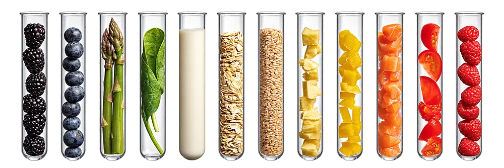 a row of test tubes containing various berries and other produce