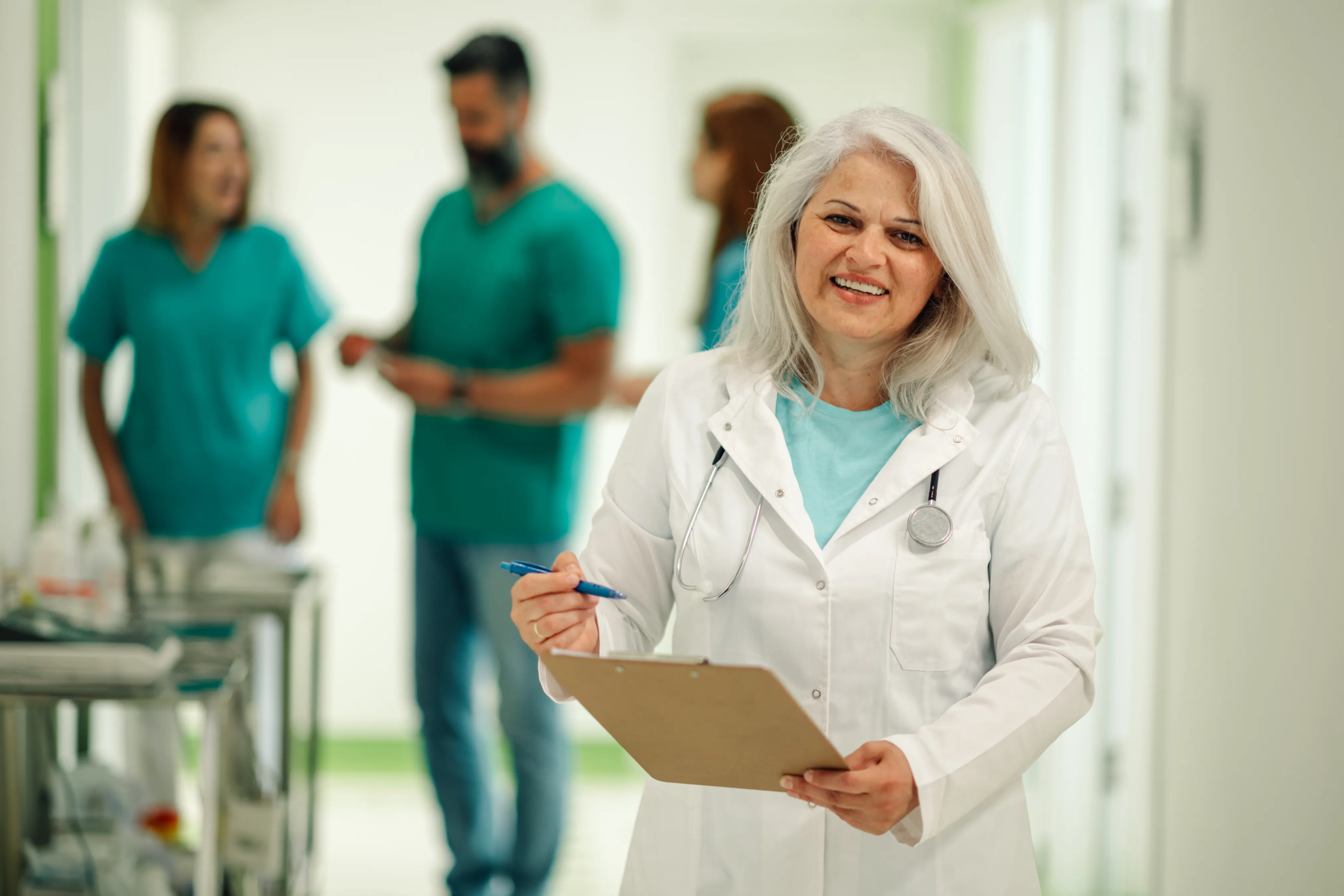 An image of a happy female doctor hold a clipboard at MEDITECH hospital that leverages Haffy Consulting for staff augmentation.