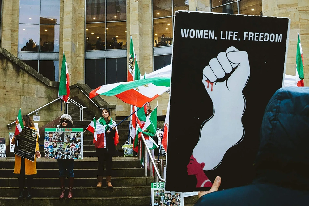 Protestors with a banner that says Women Life Freedom