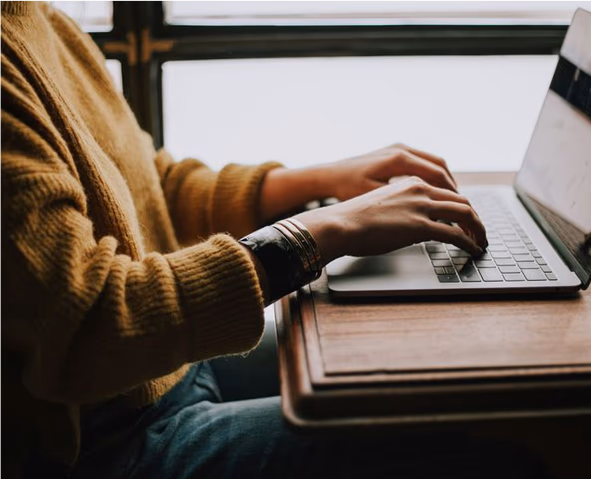 An image of someone on a laptop  typing.