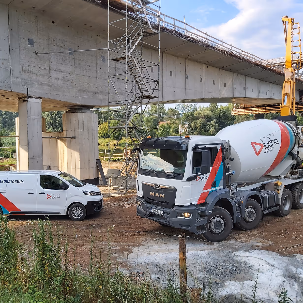 Betoniarka i samochód dostawczy przy budowie mostu w trakcie betonowania
