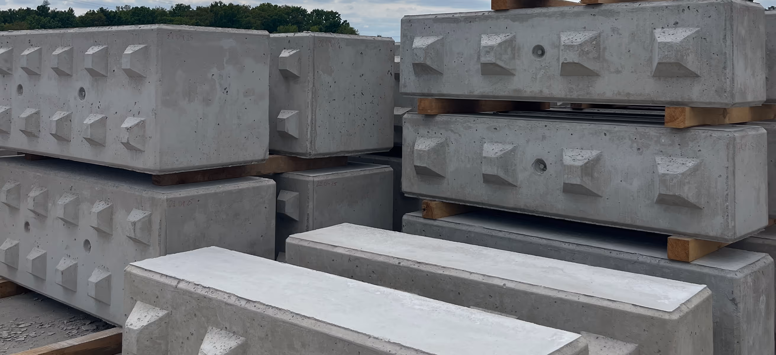 Bloki betonowe ułożone na paletach na placu budowy