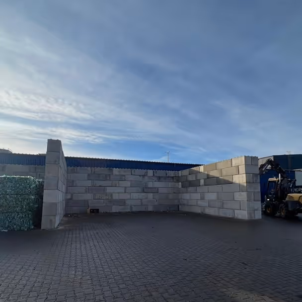 Mur betonowy na placu budowy z wózkiem widłowym obok