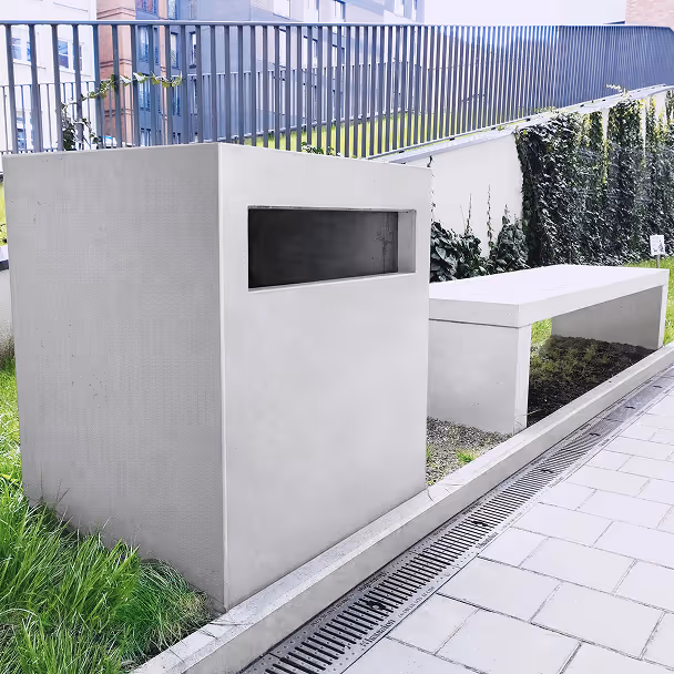 Betonowa ławka i nowoczesny mur w otoczeniu zieleni na terenie zewnętrznym