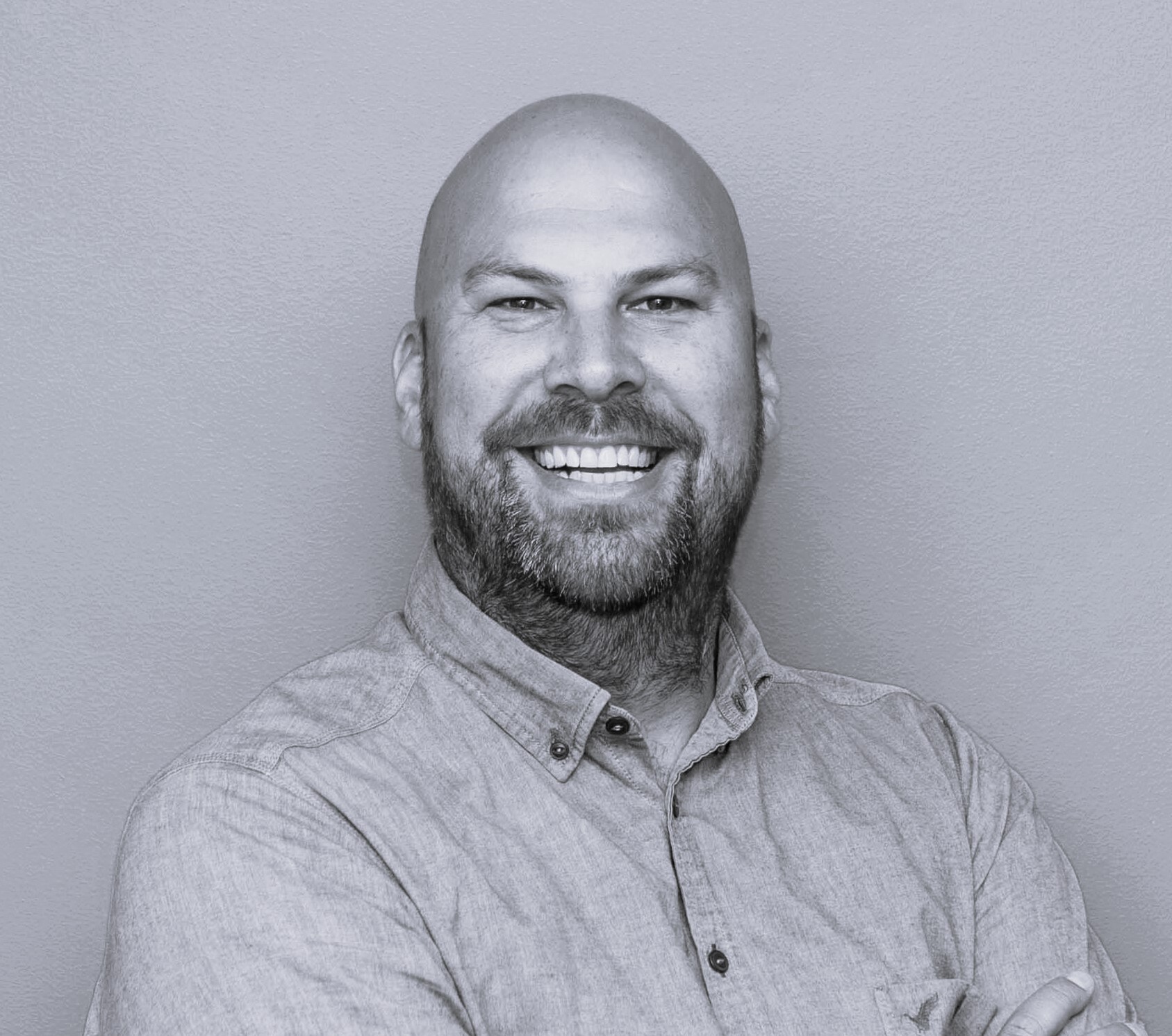Man in black and white standing against a flat background