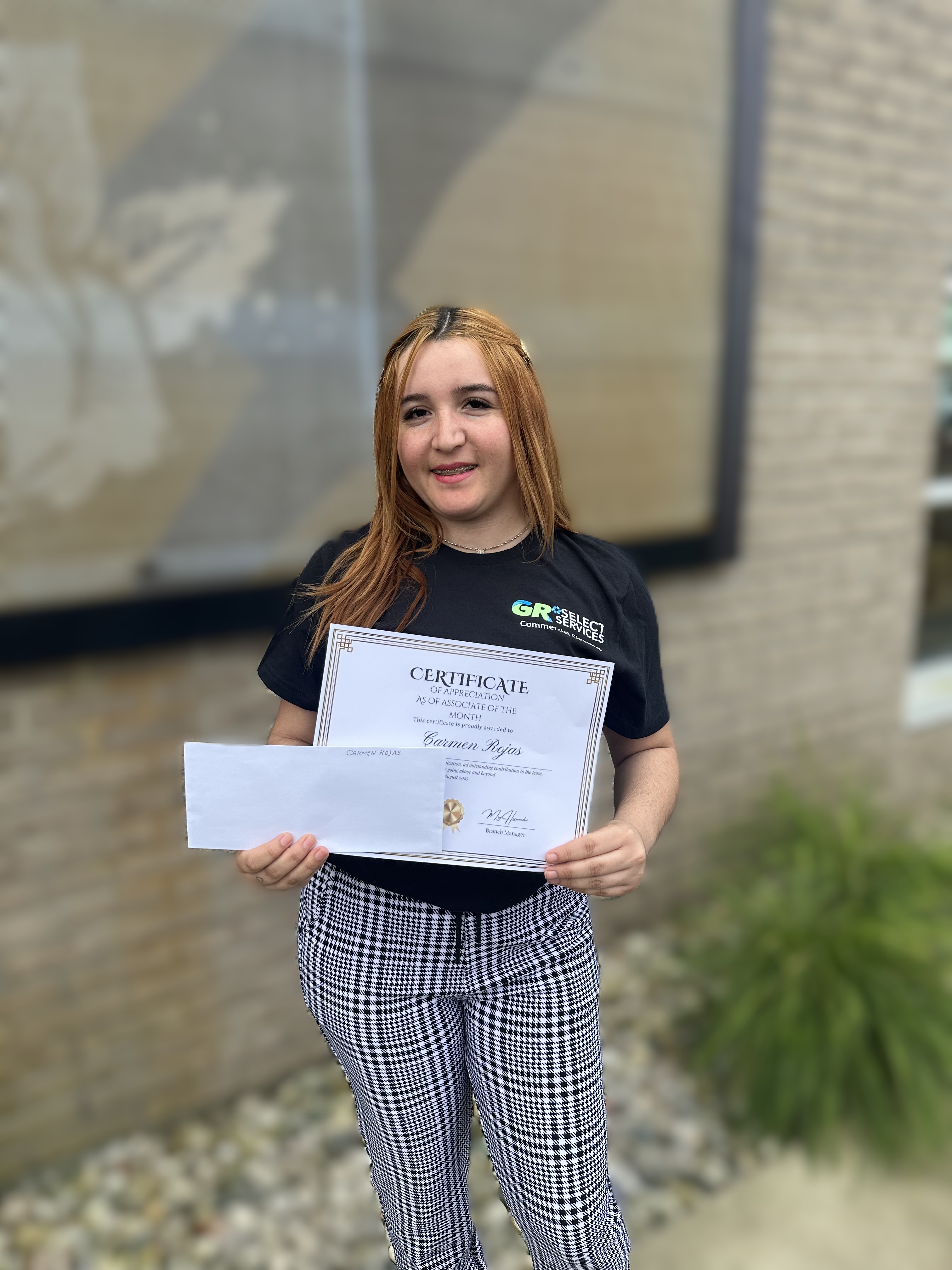 This is a person holding a certificate that recognized her as the employee of the month