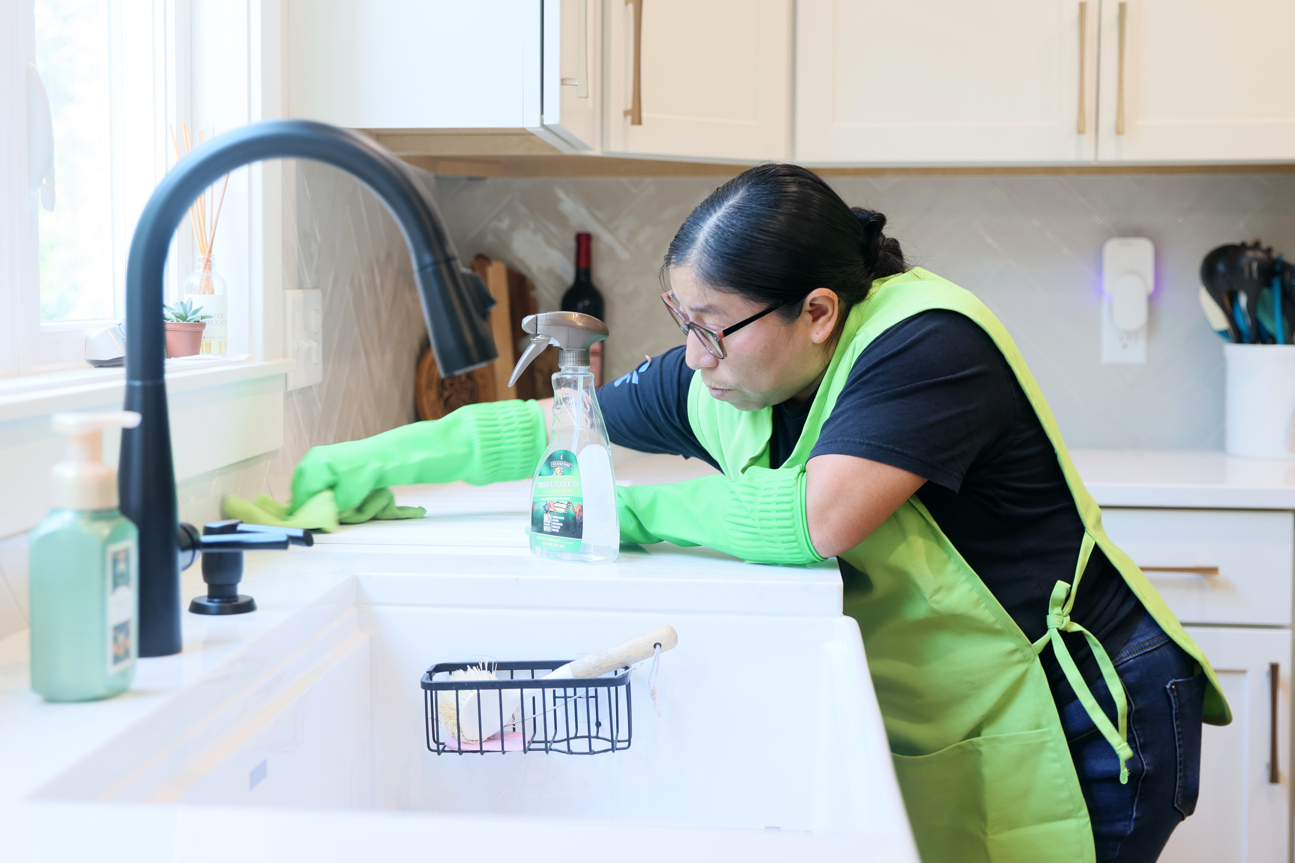 Interior of a clothing store aisle with mannequins dressed in casual sportswear and racks of folded and hanging clothes.