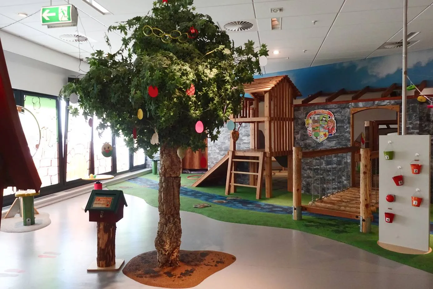 Spielbereich Högendörp mit Baum und Holzburg im famila Einkaufsland Oldenburg