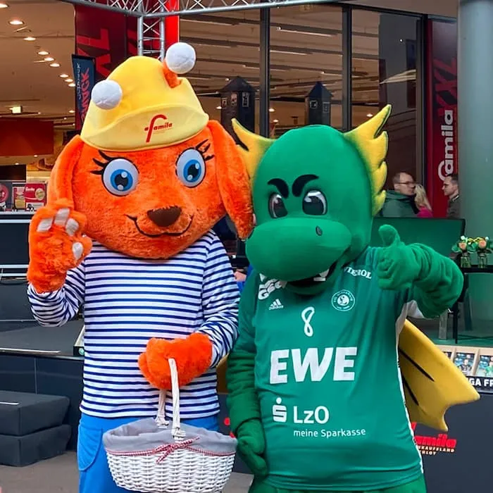 Maskottchen Luna mit grünem Drachen bei einer Kooperation von EWE und famila