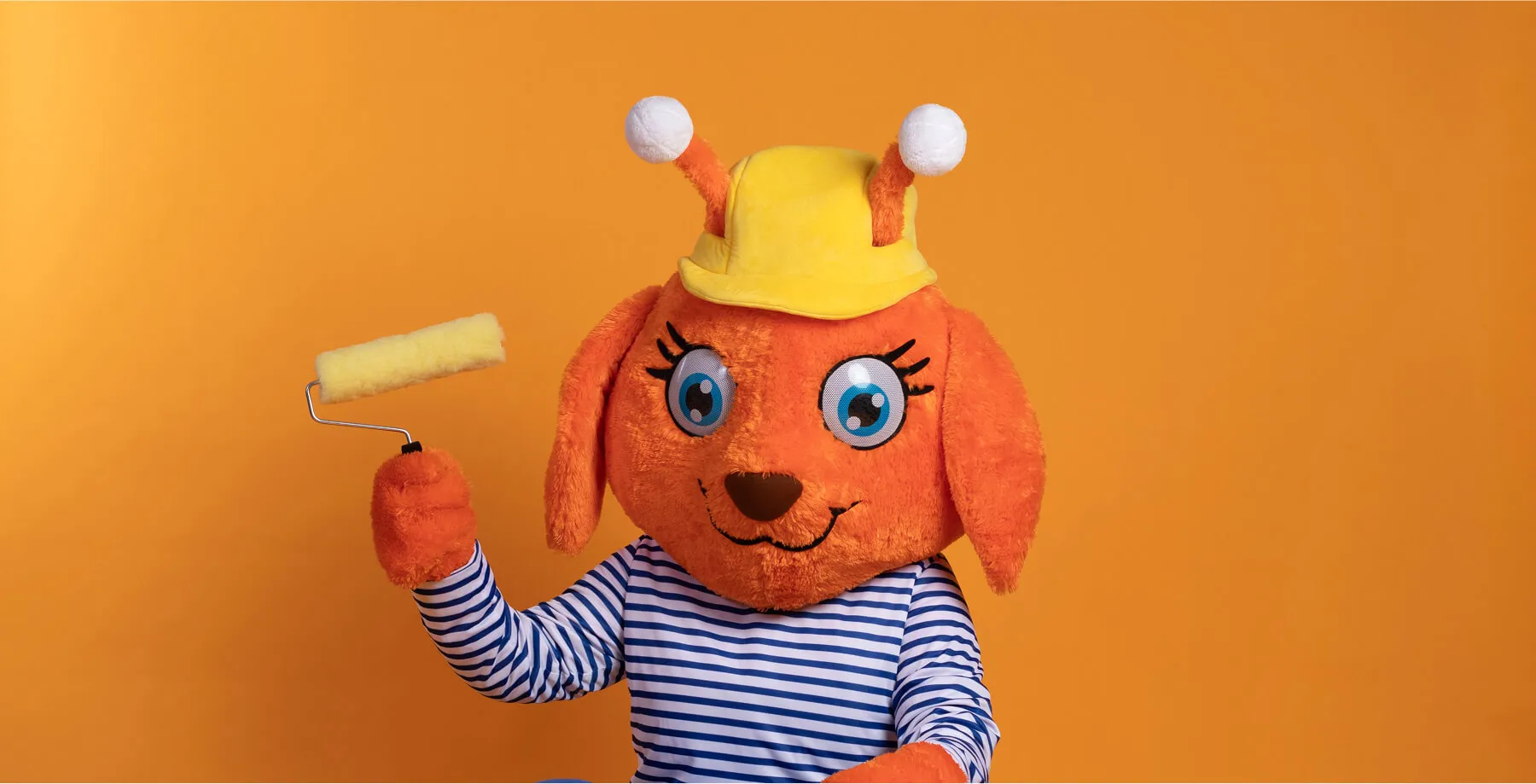 Famila-Maskottchen mit Farbroller – kreative Szene