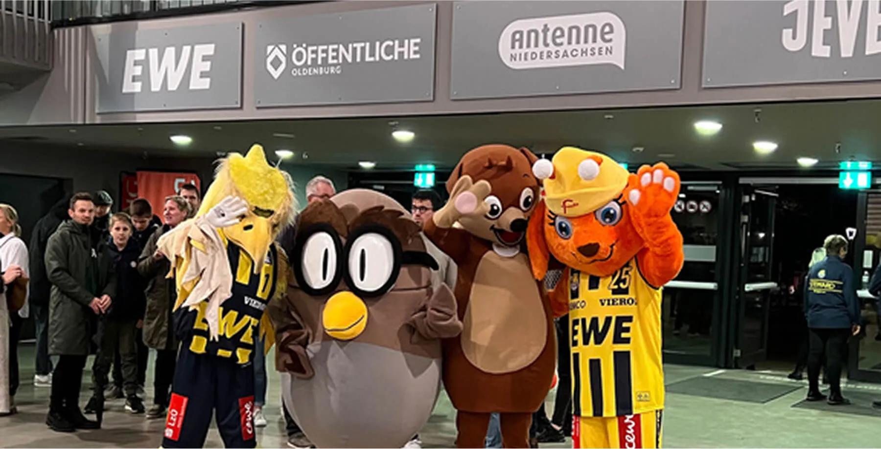 Famila-Maskottchen mit anderen Figuren vor Veranstaltungsort