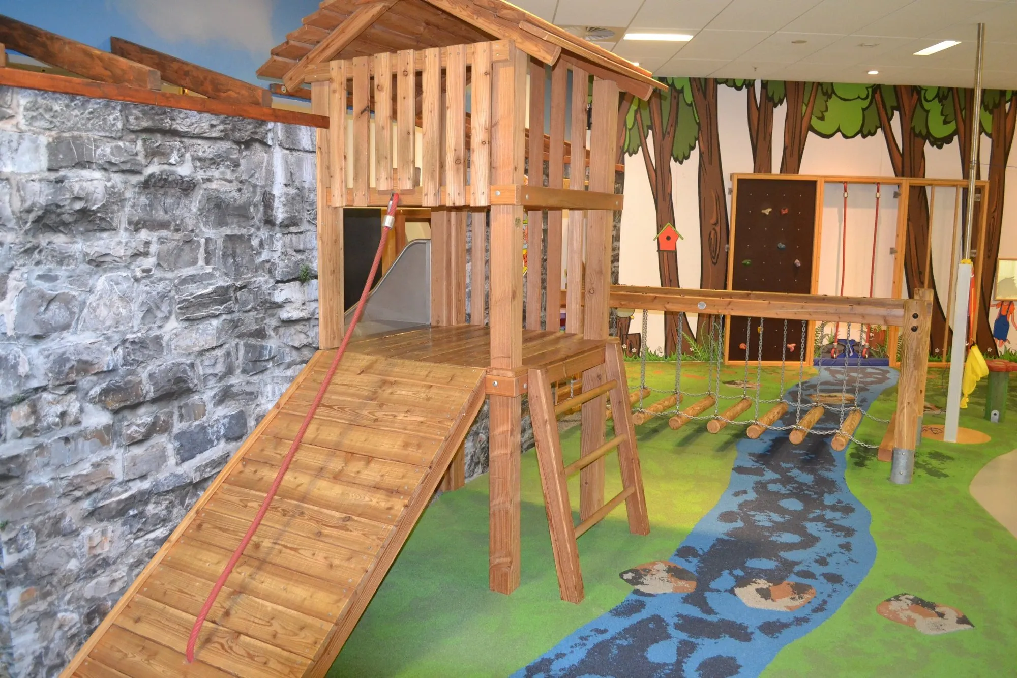 Holzspielhaus mit Hängebrücke im Indoor-Spielplatz von HÖGENDÖRP