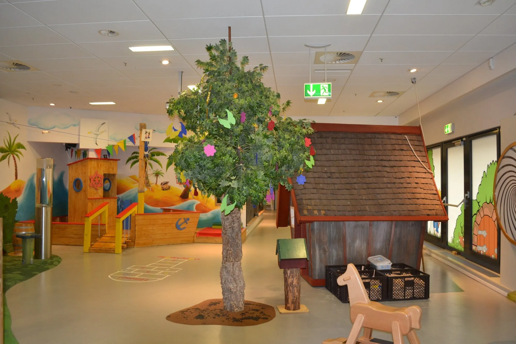 Zentraler Spielbereich mit Spielhaus, Baum und Piratenschiff im HÖGENDÖRP