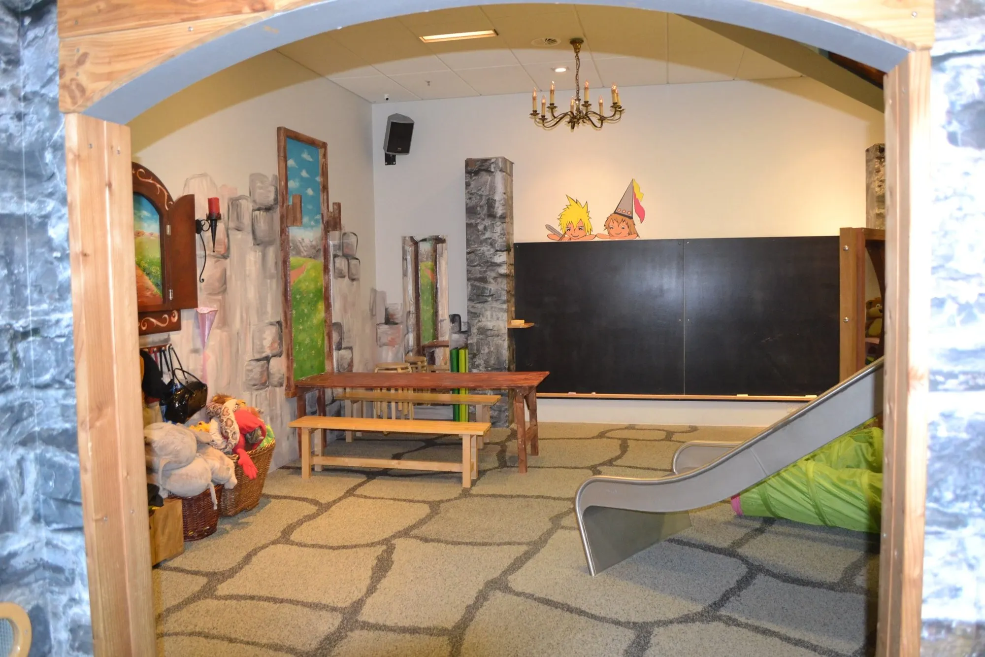 Mittelalterlicher Spielraum mit Rutsche und Holztischen im HÖGENDÖRP Indoor-Park