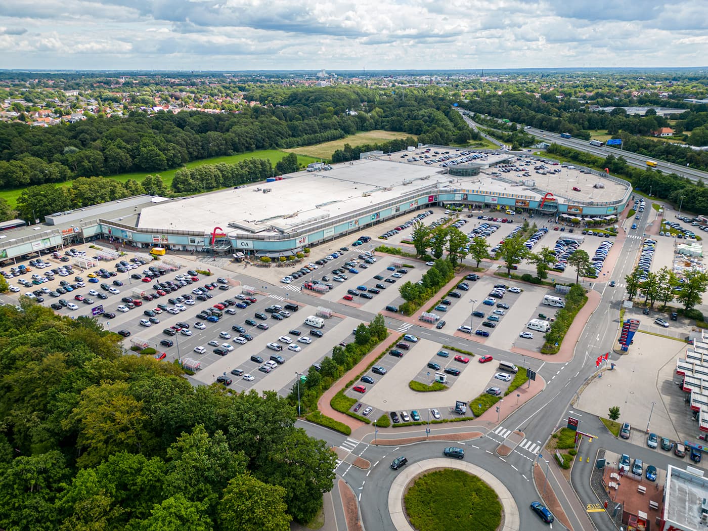 Luftaufnahme des Einkaufslandes Oldenburg mit großem Parkplatz, Kontaktinformationen und Kontaktformular für Anfragen