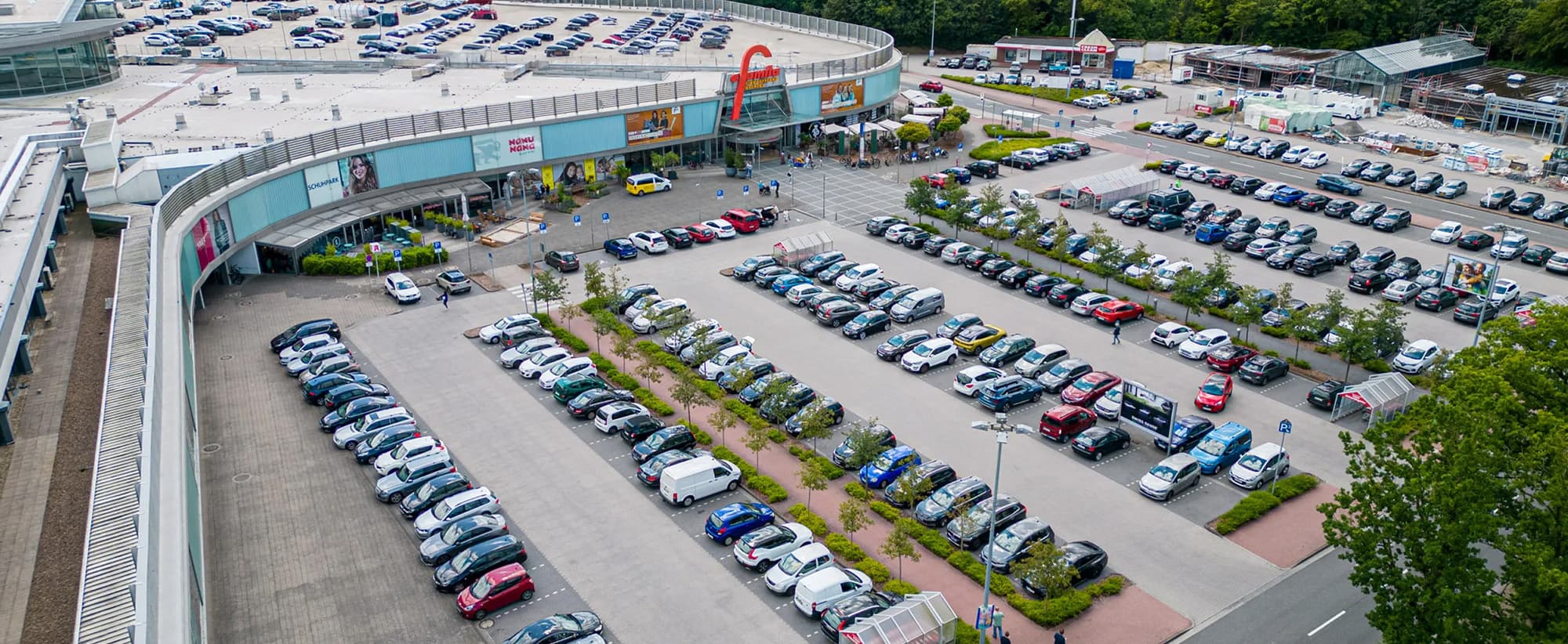 Luftaufnahme des Einkaufszentrums Einkaufsland mit großem Parkplatz und Eingangsbereich, darüber der Titel "Stellenangebote"