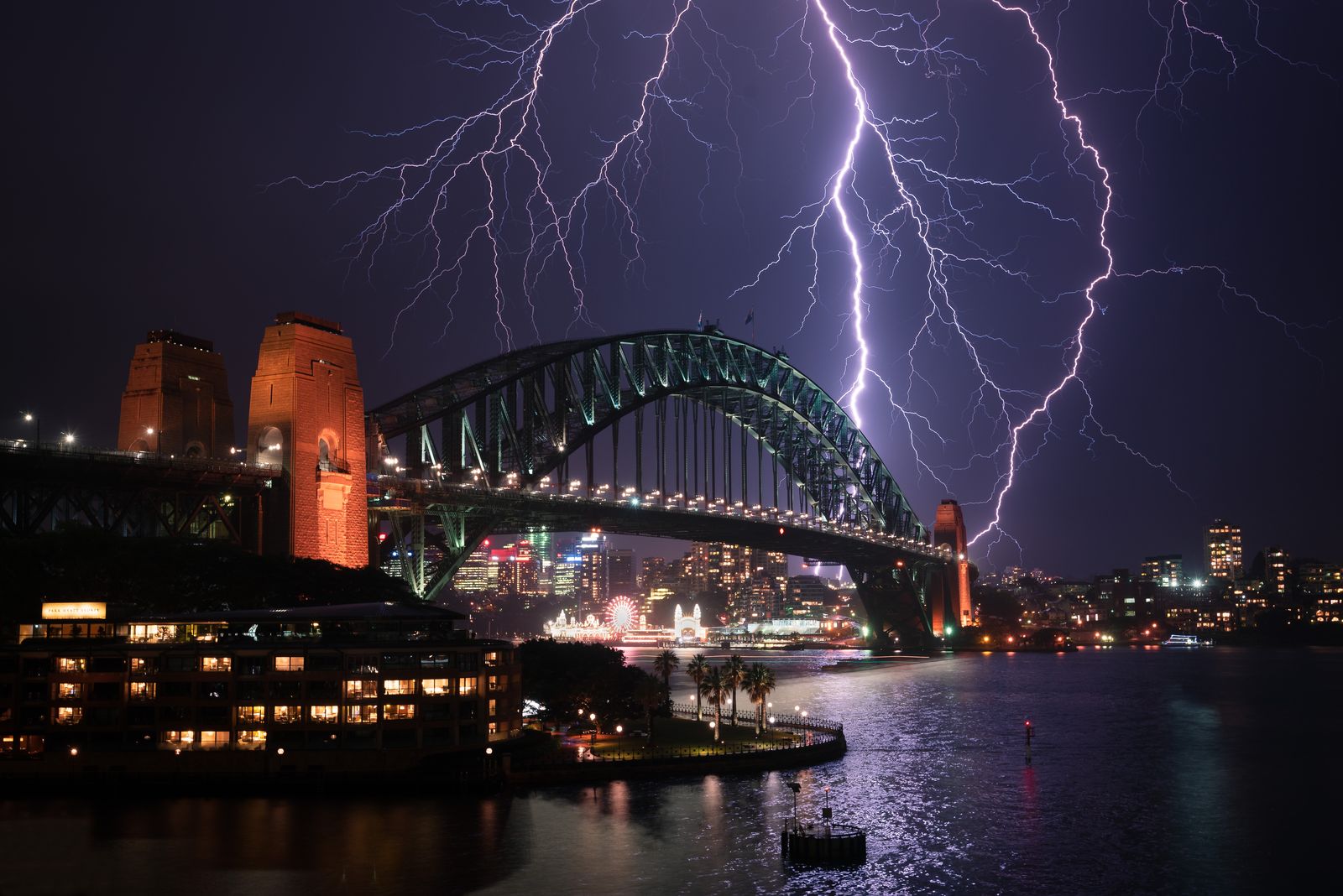 Lightning storm over Sydney Harbour Bridge representing weather-related construction delays in NSW