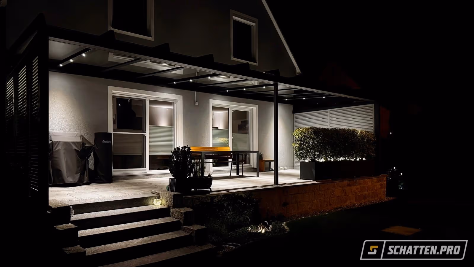 Terrassenüberdachung von SCHATTEN.PRO mit integrierten LED-Spots für eine stimmungsvolle Beleuchtung bei Nacht.