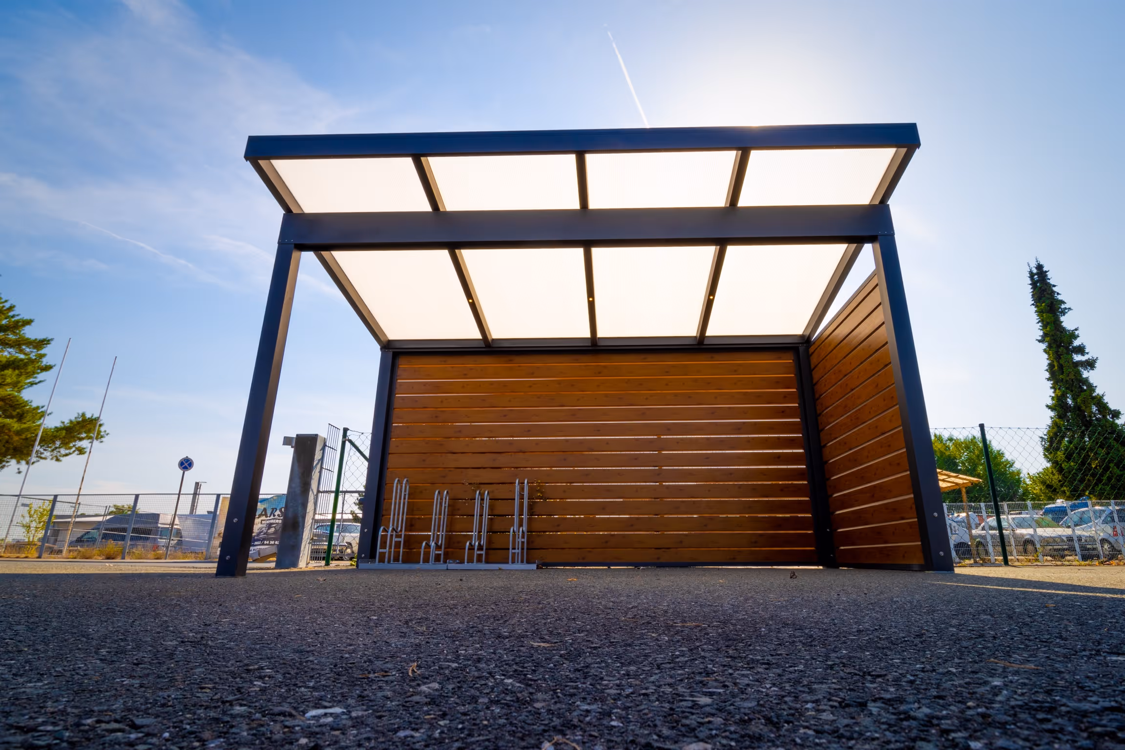  Modernes Carport mit Seitenwand aus Holz und Lichtplatten-Dach als Wetterschutz für Fahrräder