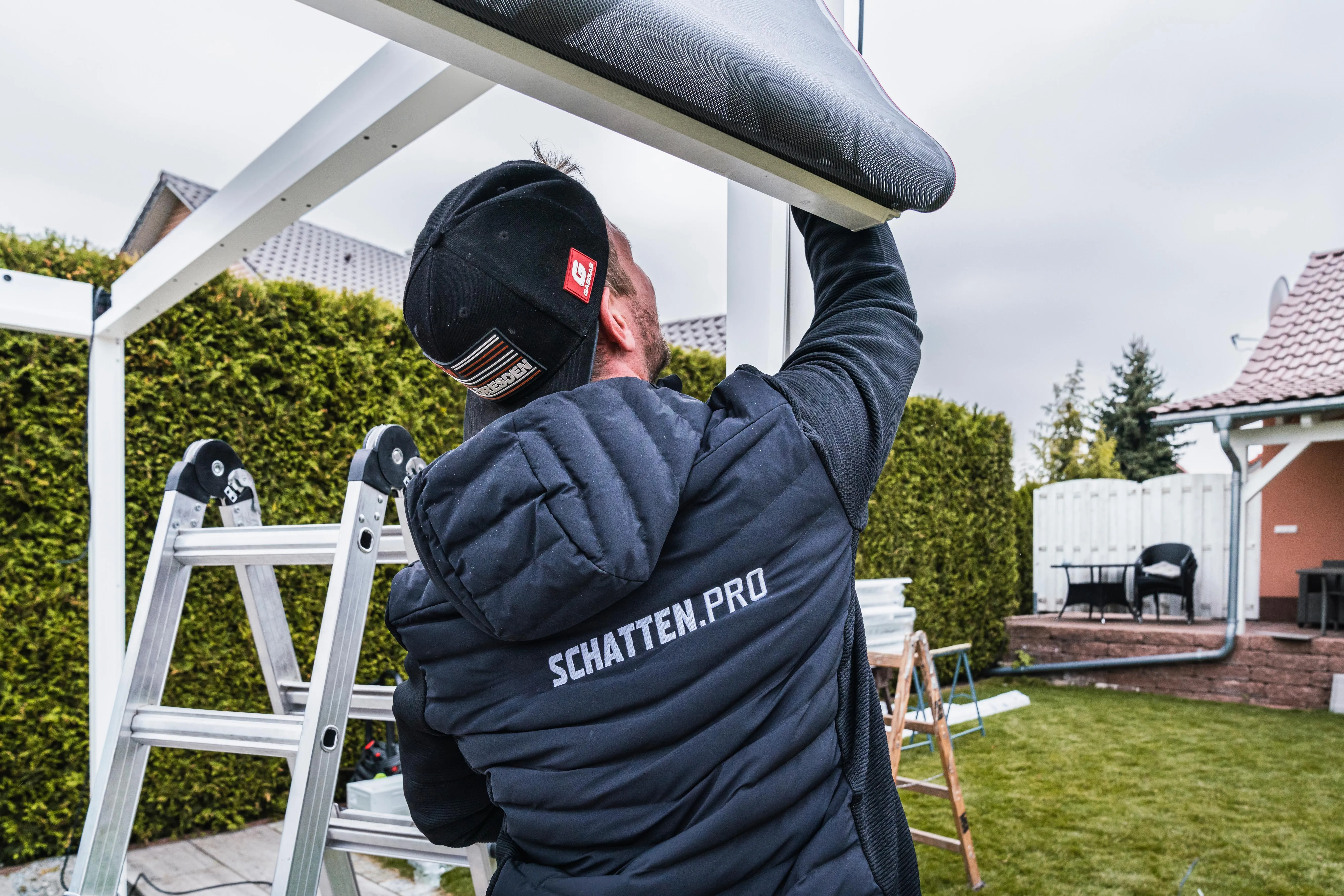 Unser Fachmann mit SCHATTEN.PRO-Arbeitskleidung installiert sorgfältig Ihre neue Beschattung.