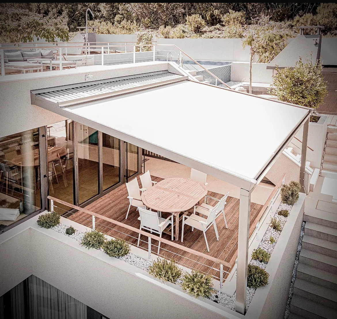 Elegante Pergola-Markise mit hellem Faltdach als Überdachung für eine große, moderne Holzterrasse.