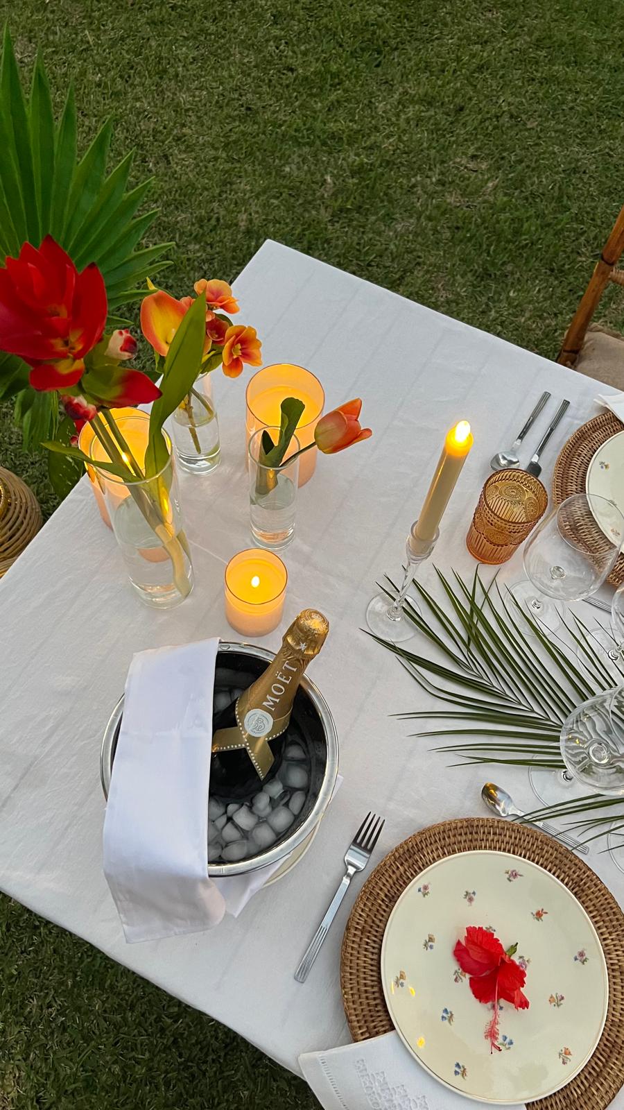 a nice set up table for romantic or family dinner by the beach, with the sunset. Special signature dinner by Maison R&V with a nice bottle of french champagne